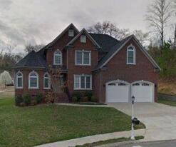 view of front of house featuring concrete driveway, an attached garage, and a front lawn