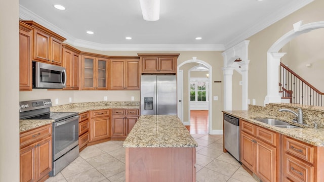 1108 City View Ter, Chattanooga, TN 37421 - kitchen with appliances with stainless steel finishes, arched walkways, a center island, light stone countertops, and brown cabinets