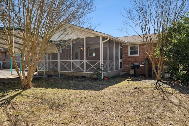 back of property with brick siding and a sunroom