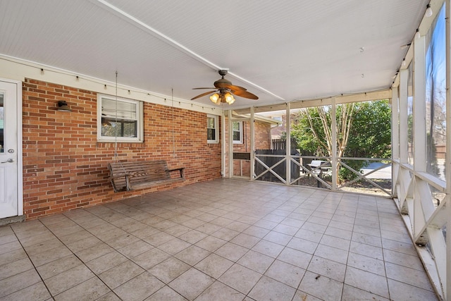 unfurnished sunroom with a ceiling fan