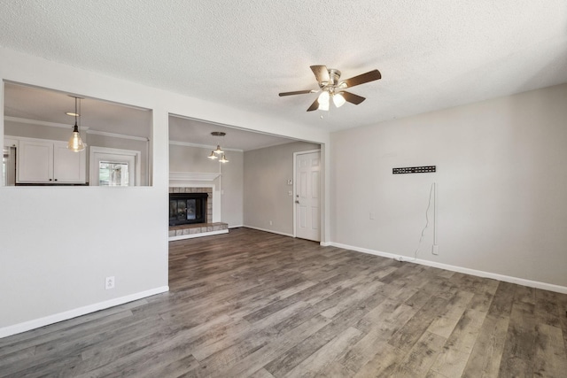 unfurnished living room featuring a textured ceiling, a fireplace, a ceiling fan, and wood finished floors