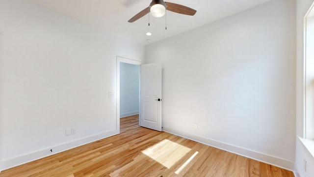 unfurnished room with ceiling fan, light wood-style flooring, and baseboards