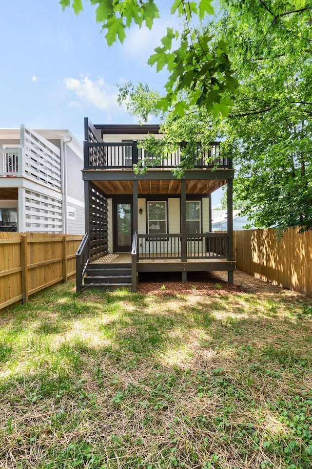 rear view of house featuring a fenced backyard and a wooden deck