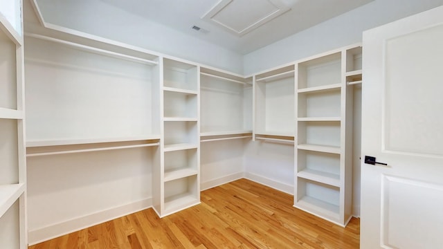 walk in closet featuring attic access, visible vents, and wood finished floors