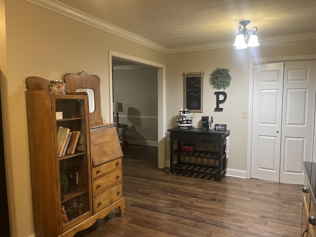 interior space featuring a textured ceiling, a chandelier, dark wood-style flooring, baseboards, and crown molding