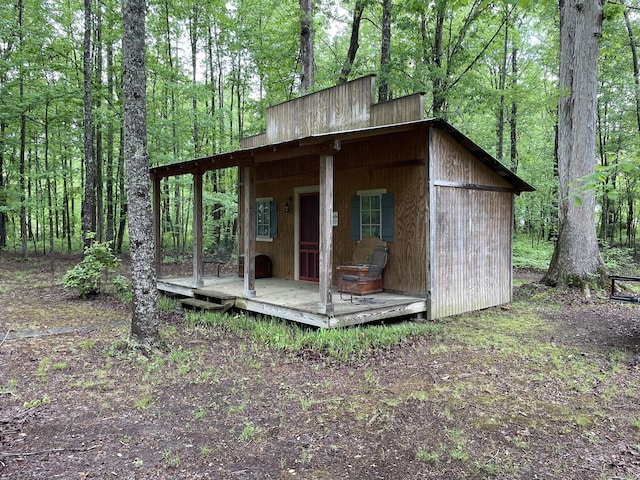 view of outdoor structure featuring a wooded view and an outbuilding