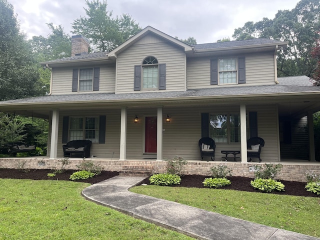 farmhouse with a porch, a chimney, and a front yard