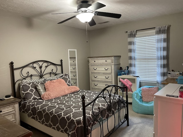 bedroom featuring visible vents, ceiling fan, a textured ceiling, and carpet flooring