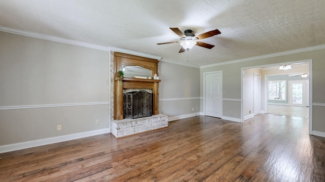 830 Motlow College Rd, Normandy, TN 37360 - unfurnished living room with a ceiling fan, a brick fireplace, wood finished floors, a textured ceiling, and crown molding