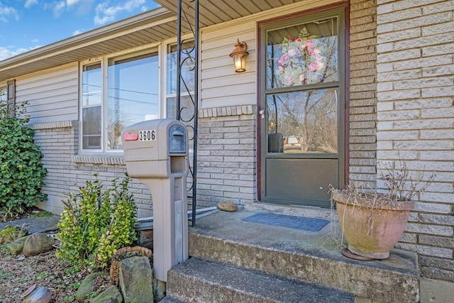 view of exterior entry with brick siding