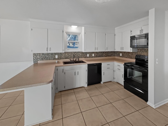 kitchen with light tile patterned flooring, a peninsula, a sink, black appliances, and tasteful backsplash