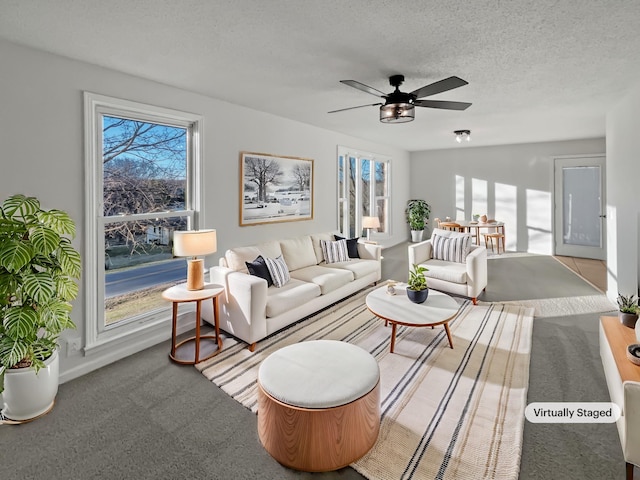 carpeted living area with ceiling fan and a textured ceiling