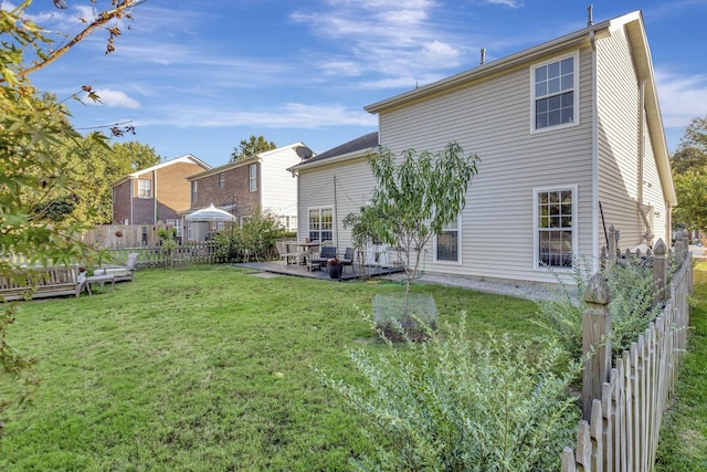 rear view of property with a yard, a patio, and fence