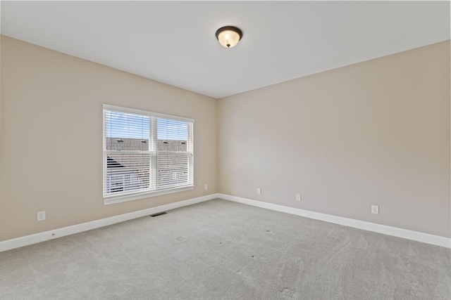 unfurnished room featuring carpet flooring, visible vents, and baseboards