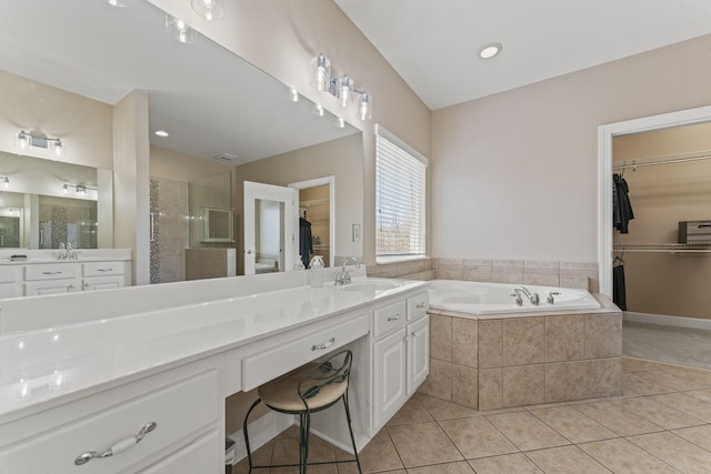 full bathroom with a garden tub, a shower stall, a spacious closet, and tile patterned floors