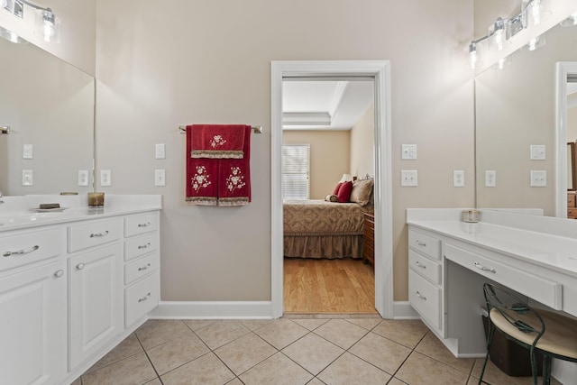 ensuite bathroom featuring ensuite bath, vanity, baseboards, and tile patterned floors