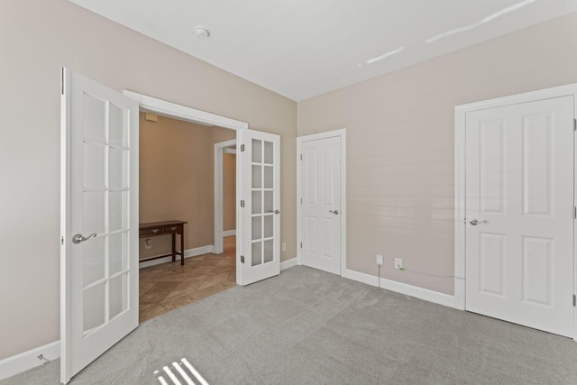 unfurnished bedroom featuring french doors, carpet, and baseboards
