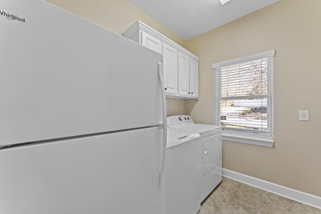 laundry room featuring washer and clothes dryer, cabinet space, and baseboards