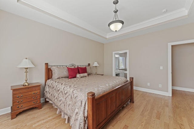 bedroom featuring crown molding, a raised ceiling, light wood-style flooring, and baseboards