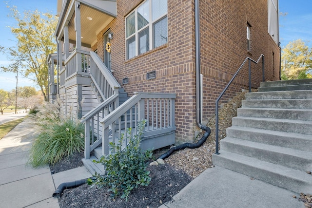 view of side of home featuring stairs and brick siding