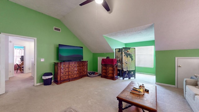 carpeted living area featuring lofted ceiling, a ceiling fan, visible vents, and a healthy amount of sunlight