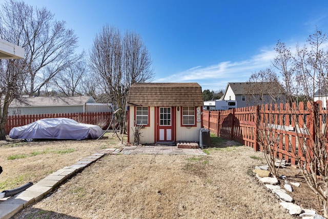 view of yard featuring a fenced backyard, an outdoor structure, and a shed