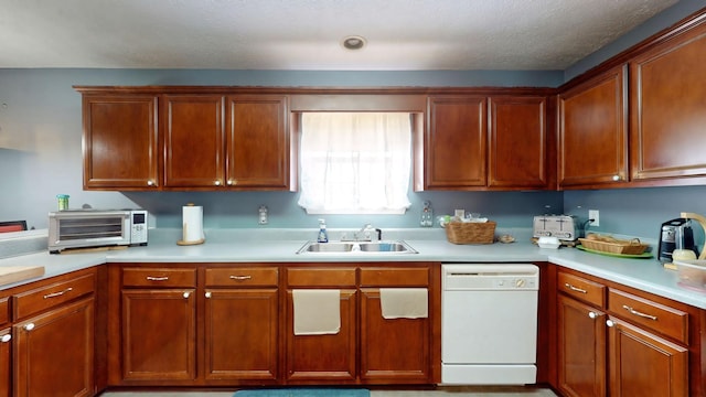 kitchen featuring dishwasher, light countertops, a sink, and a toaster