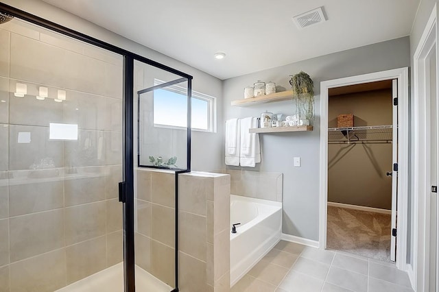 bathroom with visible vents, tile patterned floors, a walk in closet, a shower stall, and a bath