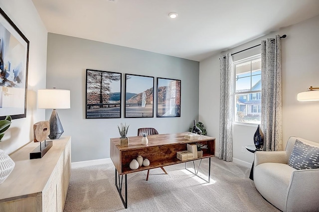 office area featuring baseboards and light colored carpet