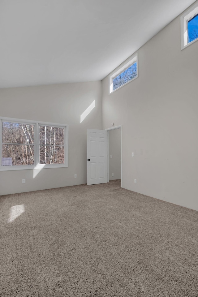 carpeted empty room with a high ceiling