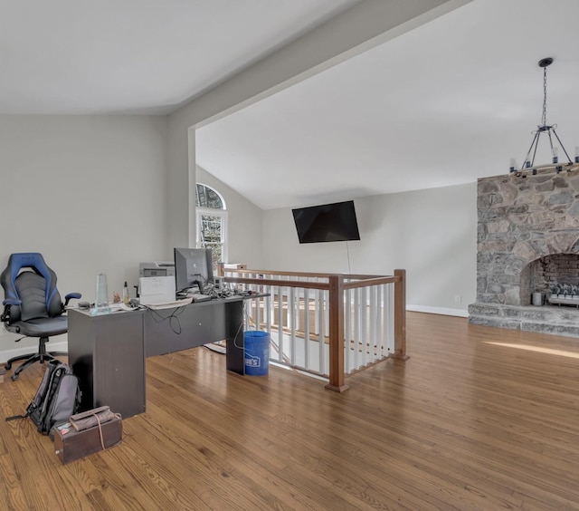 home office featuring lofted ceiling, baseboards, and wood finished floors