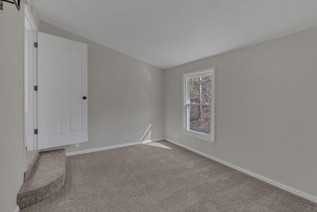 empty room featuring carpet floors and baseboards