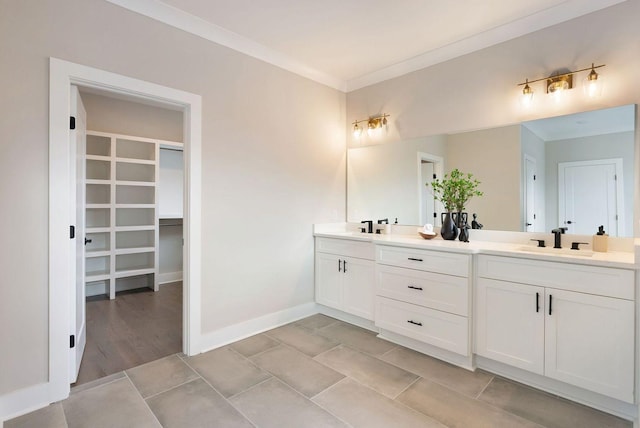 bathroom with double vanity, crown molding, and a sink