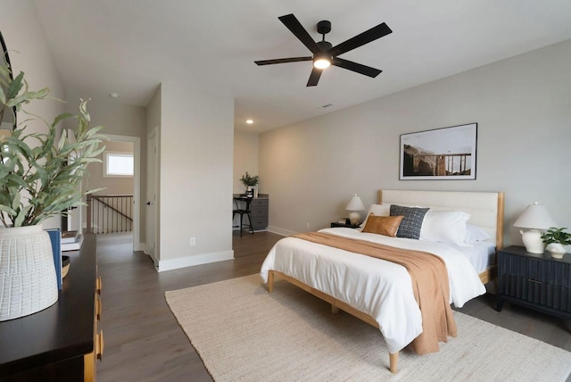 bedroom featuring a ceiling fan, baseboards, and wood finished floors