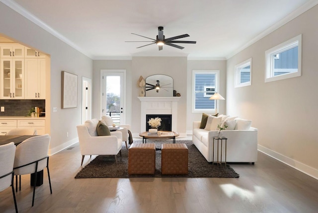 living room with a fireplace, crown molding, and wood finished floors