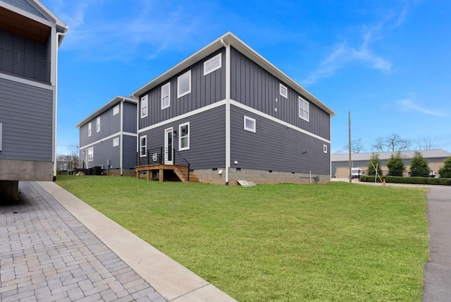 back of property featuring crawl space, board and batten siding, and a lawn