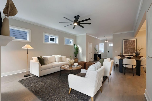 living room with baseboards, ceiling fan, wood finished floors, and crown molding