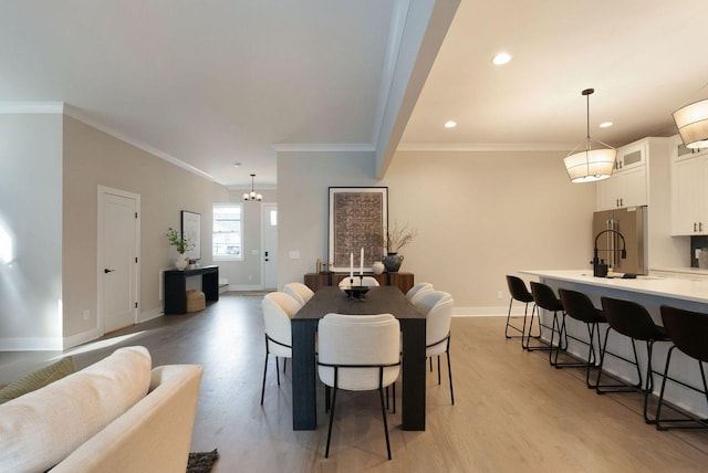 dining space featuring recessed lighting, baseboards, crown molding, and light wood finished floors