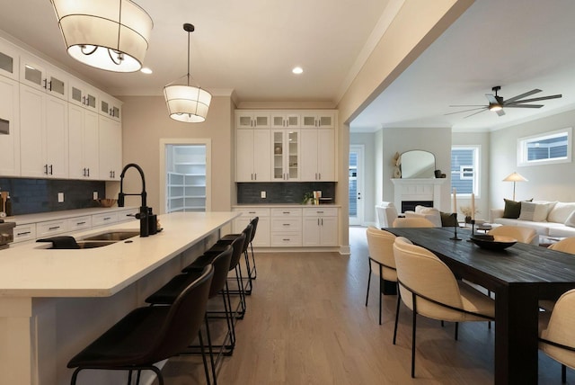 kitchen featuring ornamental molding, light countertops, a sink, and a fireplace