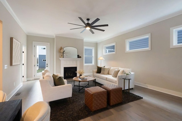 living area featuring ornamental molding, visible vents, baseboards, and wood finished floors