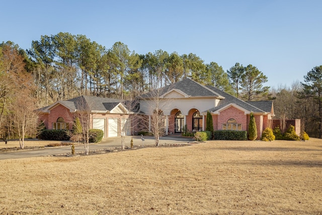 view of front of house with a garage, brick siding, driveway, and a front lawn