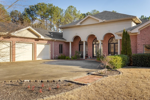 view of front facade featuring a garage, concrete driveway, brick siding, and roof with shingles