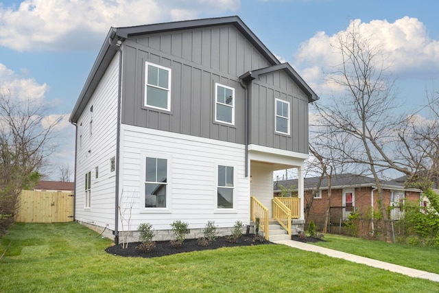 view of front of house with board and batten siding, a front yard, and fence