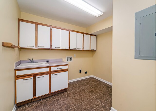 clothes washing area with cabinet space, electric panel, baseboards, hookup for a washing machine, and a sink