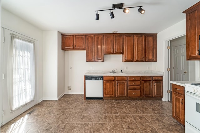 kitchen featuring a healthy amount of sunlight, white appliances, light countertops, and a sink