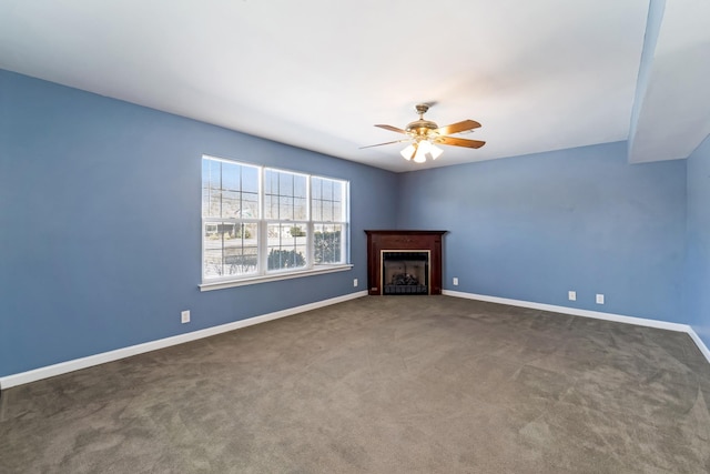 unfurnished living room with a fireplace, carpet flooring, a ceiling fan, and baseboards