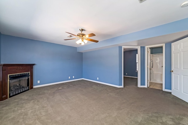 unfurnished living room with carpet floors, ceiling fan, a fireplace, and baseboards