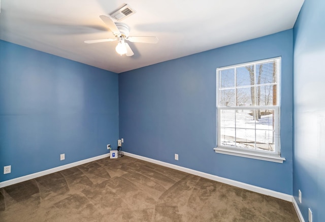 spare room featuring carpet floors, baseboards, visible vents, and ceiling fan