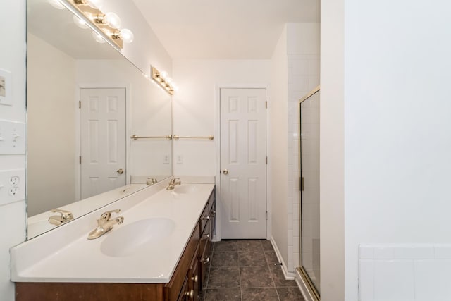 bathroom with double vanity, a stall shower, and a sink