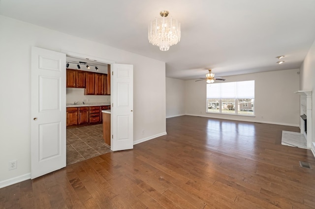 unfurnished living room featuring a high end fireplace, visible vents, dark wood finished floors, and baseboards